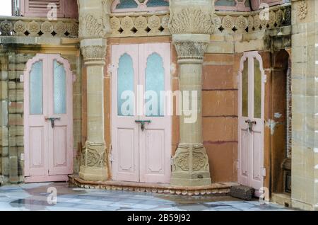 Intricately carved architecture and wooden doors with coloured glass at Vijaya Vilas Palace, Mandvi, Kutch, Gujarat, India Stock Photo