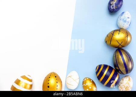 Happy Easter. Frame for text made of easter eggs trendy colored classic blue, white and golden on blue. Minimal style, top view, flatlay, copy space. Stock Photo