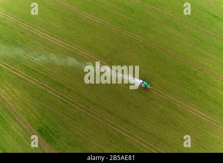 Gammelin, Germany. 05th Mar, 2020. A tractor drives over a field and distributes plant fertiliser with a spreader (aerial view with a drone). The environmental protection organization BUND has asked the state government of Mecklenburg-Western Pomerania to implement the state programme for soil protection. The aim is to maintain or restore the good condition of the soil in the fields, meadows and pastures. Credit: Jens Büttner/dpa-Zentralbild/dpa/Alamy Live News Stock Photo