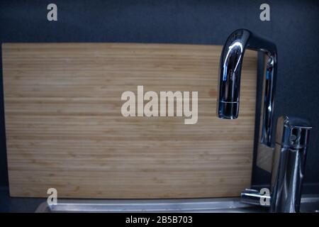Wooden board in the kitchen and sink. Scandinavian home style. Interior with copy space Stock Photo