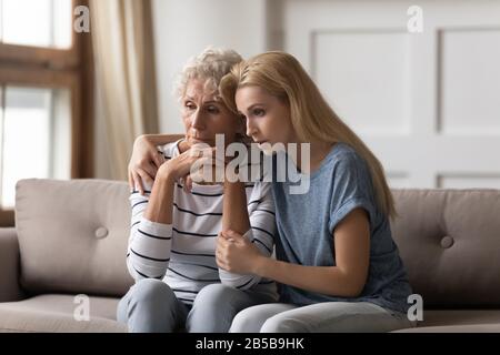 Supportive adult daughter comfort distressed mature mom Stock Photo
