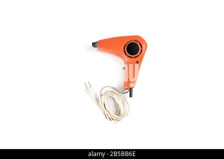 Vintage orange hair dryer on white background with rolled cable buttom. Stock Photo