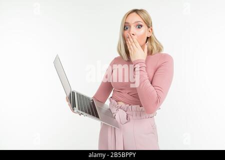 surprised girl holds a laptop in her hands on a white studio background Stock Photo
