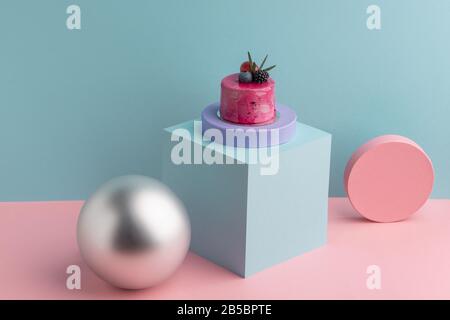 Beautiful pink mousse cake decorated with berries and rosemary Stock Photo