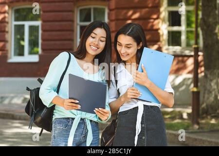 Portrait Of Two Smiling Student Girls Discussing Study Project Outdoors Stock Photo