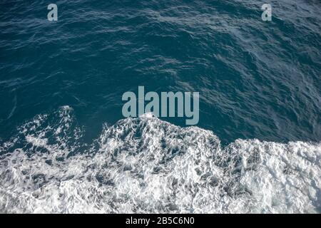 Natural background of blue-green sea water with foam. Stock Photo