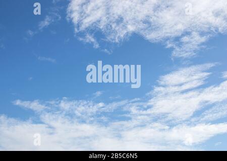 White fluffy clouds on bright blue sky Stock Photo