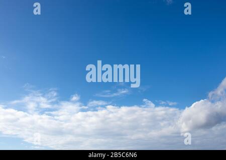 White fluffy clouds on bright blue sky Stock Photo