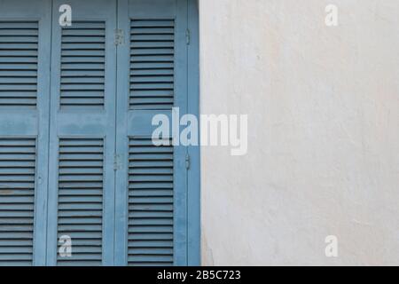 Blue shutters on white wall in Aegina island Stock Photo