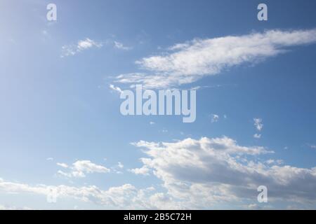 White fluffy clouds on bright blue sky Stock Photo