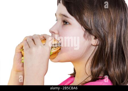portrait of a beautiful girl, teenager and schoolgirl, holding a hamburger on a white background. Stock Photo