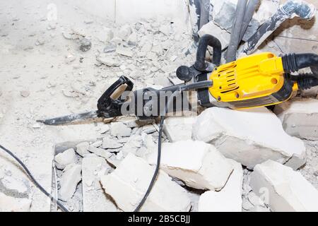 pieces of broken wall next to the jackhammer Stock Photo