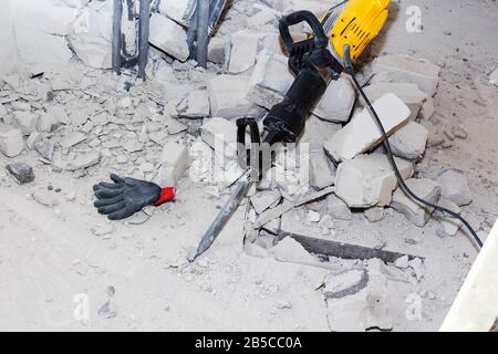 pieces of broken wall next to the jackhammer Stock Photo