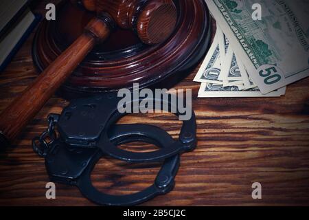 Handcuffs and a wooden gavel in front of manila folders Stock Photo