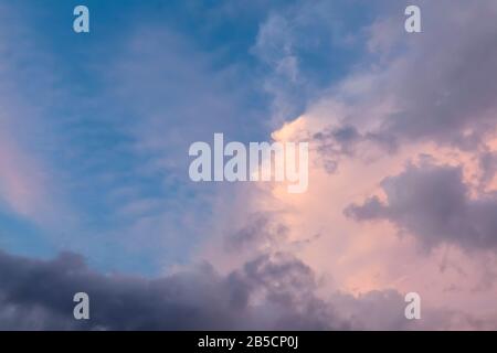 Beautiful pink clouds in the blue sky during sunset dusk hours. Natural cloudscape background pattern Stock Photo