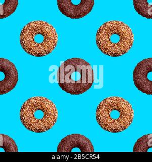 Seamless pattern of chocolate and nut donuts on blue background isolated top view, colorful donut repeating ornament, bagels wallpaper, sweet cakes Stock Photo