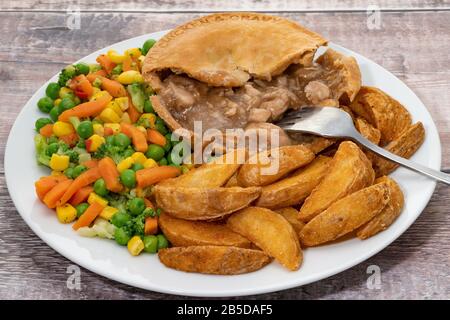 Chicken pie with vegetables and potato fries with gravy Stock Photo
