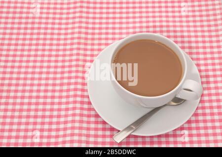 Cup of tea placed on a checked pattern tablecloth Stock Photo
