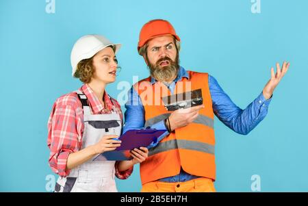 job and occupation. confident electrical and technician. engineers couple working together on building blueprint. work at construction site or factory. Civil engineering. industrial business partner. Stock Photo