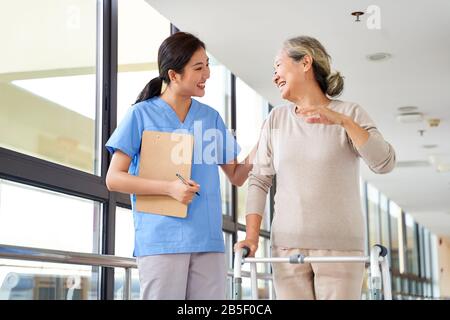 happy senior asian woman talking to physical therapist in rehab center Stock Photo
