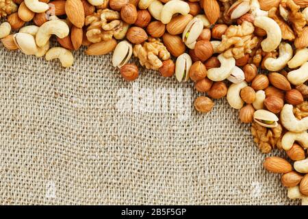 Roasted peanuts in their shells and peeled in a brown cup, against a gray wooden table. Organic vegetarian protein, macro. Stock Photo