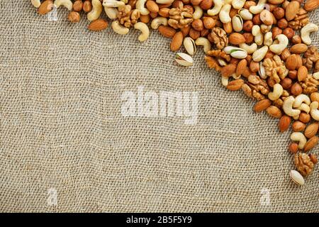 Roasted peanuts in their shells and peeled in a brown cup, against a gray wooden table. Organic vegetarian protein, macro. Stock Photo