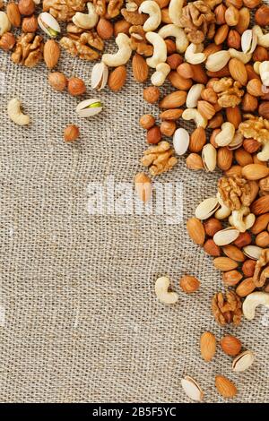 Roasted peanuts in their shells and peeled in a brown cup, against a gray wooden table. Organic vegetarian protein, macro. Stock Photo