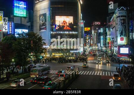 Night photography of a crowed of pedestrians crossing a four way zebra crossing at Shibuya crossing in central Tokyo, Japan Stock Photo