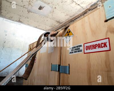 Radiation warning sign on the Hazardous materials transport label Class 7 at the wooden box package in the container of transport truck Stock Photo