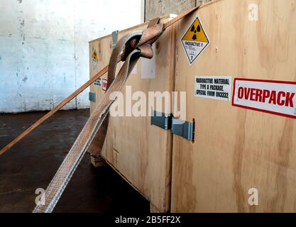 Radiation warning sign on the Hazardous materials transport label Class 7 at the wooden box package in the container of transport truck Stock Photo