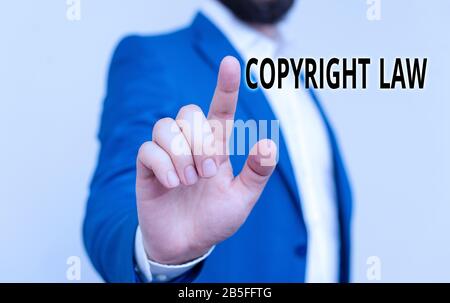 Writing note showing Copyright Law. Business concept for body of law that governs the original works of authorship Businessman blue suite and white sh Stock Photo