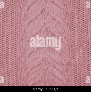 Knitted braids pink sweater material canvas texture close up. Stock Photo