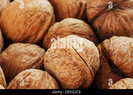 Natural walnut background pattern texture Abstract walnuts heap pattern background Blurred edges frame Natural food in-shell nuts walnuts pattern back Stock Photo