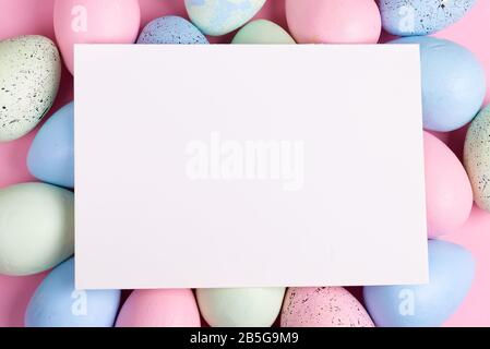 Happy Easter greeting card from handmade painted colorful eggs and paper sheet for congratulation text. Stock Photo