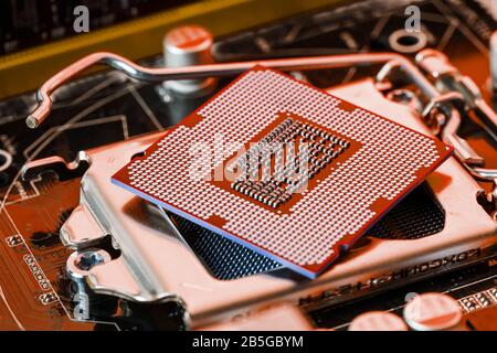 The central processor on the computer motherboard in red colors. PC repair, technician and industry support concept. Stock Photo
