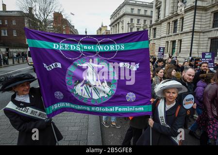 London, UK.  8 March 2020.  Women dressed as suffragettes hold up a banner as thousands of people take part in the annual March 4 Women on International Women's Day. The event this year celebrates the power and passion of women and girls who are on the frontline of responding to climate change.  The walk through central London from Whitehall Place ends with a rally in Parliament Square.  Credit: Stephen Chung / Alamy Live News Stock Photo