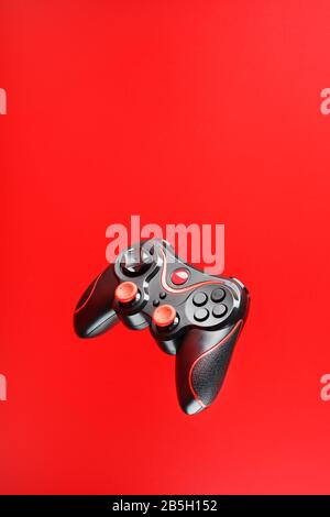 Game controller in flight on red background. Interactive entertainment. The concept of gamers Stock Photo
