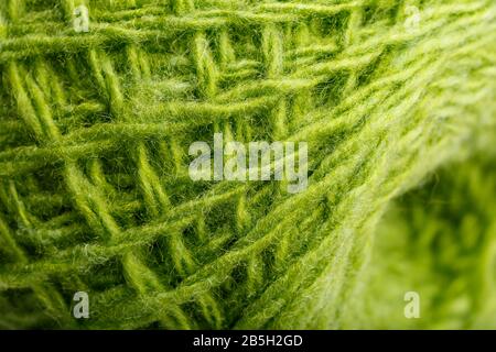 Wool yarn close up colorful green threads for needlework in macro. Background texture fabric for knitting needle. Full screen wool yarn. Stock Photo