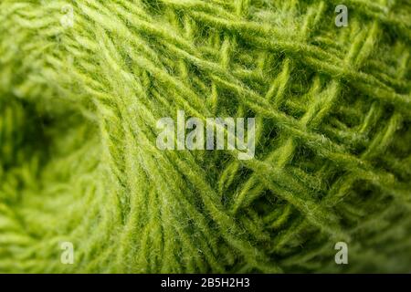 Wool yarn close up colorful green threads for needlework in macro. Background texture fabric for knitting needle. Full screen wool yarn. Stock Photo