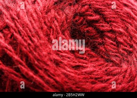 Wool yarn close-up colorful red thread for needlework in macro. Background texture fabric for knitting needle. Full screen wool yarn. Stock Photo
