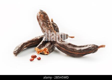 Carob carob fruit and seeds on white background. Isolate. Organic carob beans, a healthy alternative to cocoa. Stock Photo