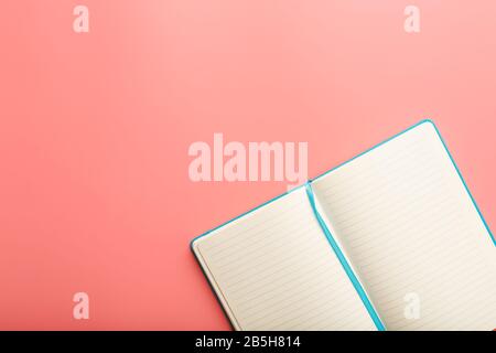 Open a laptop with blank pages on a pink background. Top view, copy space. Elements of notebook sheets with bookmark Stock Photo