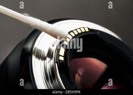 Gentle cleaning with a cotton swab camera Lens with a beautiful optical block close-up. Macro In full screen Stock Photo