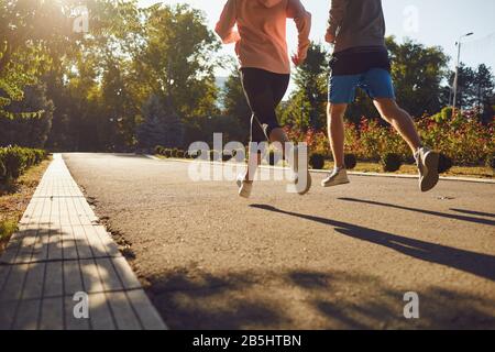A man and a woman in sportswear are running along the city street in the morning. Runners are running in the city..Jogging. Health. Healthy lifestyle.
