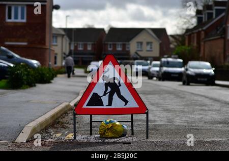 'Road works' sign in the middle of the street residential area. Stock Photo