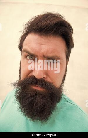 Strict face. Beard fashion barber. Handsome guy. Masculinity concept. Suspicious look. Man bearded hipster stylish beard grey background. Perceptions of male beauty. Stylish beard and mustache care. Stock Photo