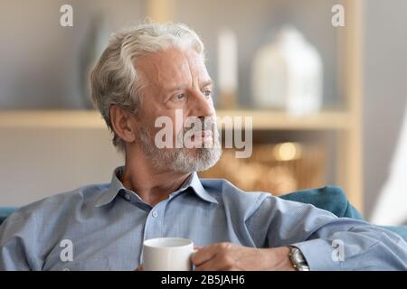 Thoughtful elderly man loo in distance thinking or mourning Stock Photo