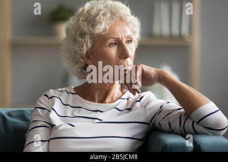 Pensive mature lady feel lonely thinking at home Stock Photo