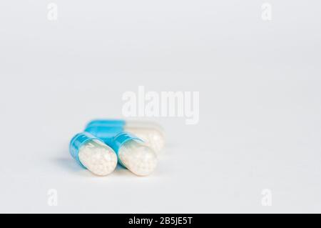 Closeup blue-white antibiotics capsule pills. Pharmacy background. Antimicrobial drug resistance. Pharmaceutical industry. Global healthcare. Stock Photo