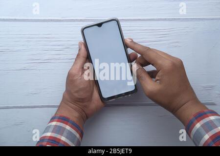Man using smartphone with blank white screen Stock Photo